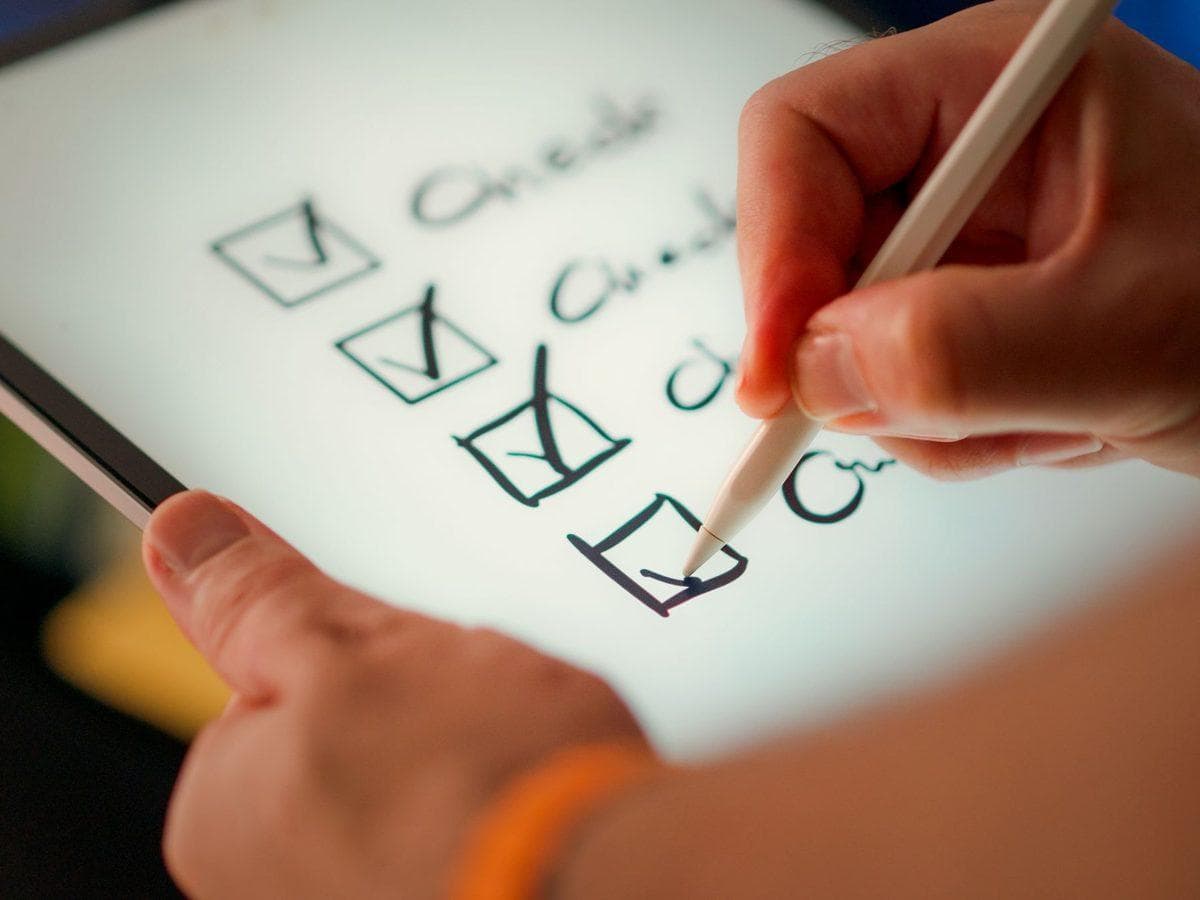 Technikerin mit Checkliste am Notebook